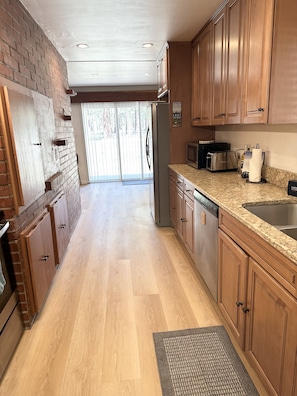 A kitchen with wooden cabinets, a stainless steel refrigerator, a microwave, and a dishwasher. - Hch0681 - Red Lake Lodge 3 Bedroom Home (South Lake Tahoe)