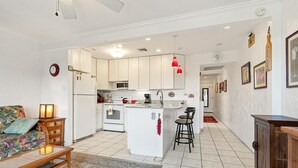 A compact living space with a kitchenette, a dining area, and a sofa. - Big Island Casa De Emdeko B326 1 Bedroom Apts (Kailua-Kona)
