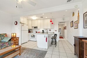 A compact living space with a kitchenette, a dining area, and a sofa. - Big Island Casa De Emdeko B326 1 Bedroom Apts (Kailua-Kona)