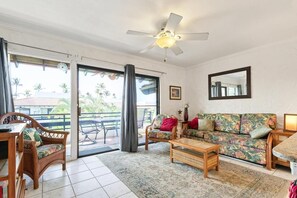 A living room with a sofa, coffee table, and a ceiling fan. - Big Island Casa De Emdeko B326 1 Bedroom Apts (Kailua-Kona)