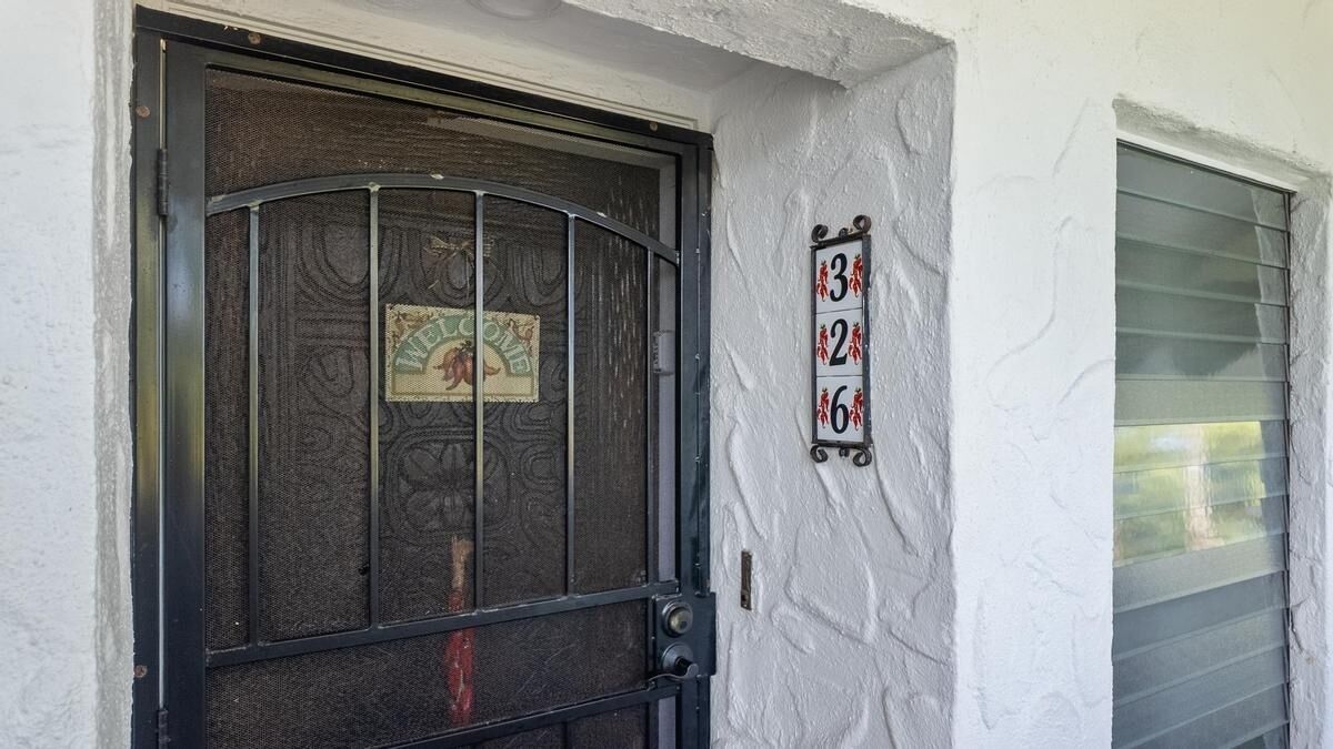 A door with a decorative metal grille and a sign with numbers 3, 2, 6.