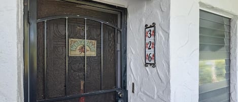 A door with a decorative metal grille and a sign with numbers 3, 2, 6.