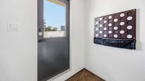 Eine Tür mit Fenster, ein rundes Wandobjekt und ein Lichtschalter.