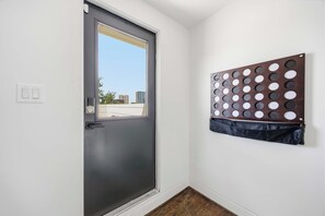 Eine Tür mit Fenster, ein rundes Wandobjekt und ein Lichtschalter.
