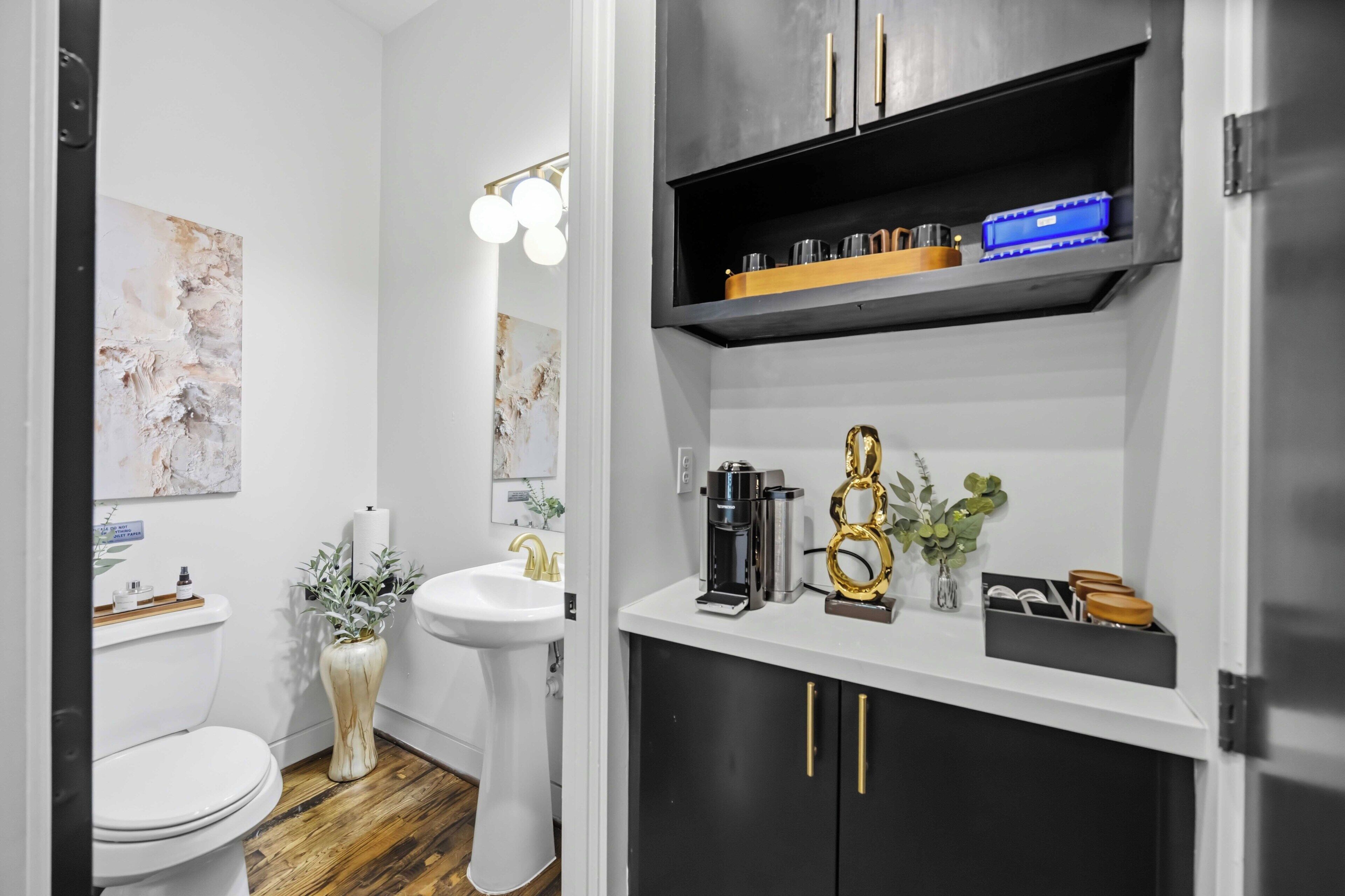 A modern bathroom with a toilet, sink, and a shelf with toiletries.