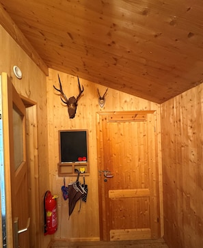A wooden interior with a door, a mounted deer head, a blackboard, and a fire extinguisher. - Chalet # 49 with 3 BR for up to 8 people (Annaberg)