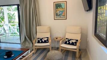 A room with two chairs, a small table, a globe, and a framed picture of Seychelles.