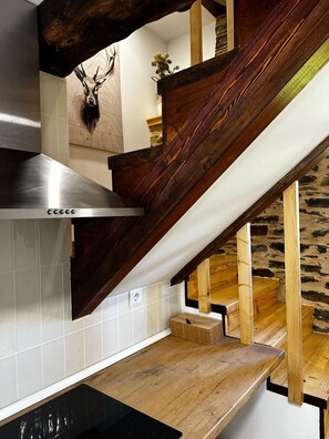 A kitchen with a wooden staircase, a stainless steel range hood, and a mounted deer head. - Near the river, on the Primitive Route, a 10-minute walk from downtown Lugo (Lugo)