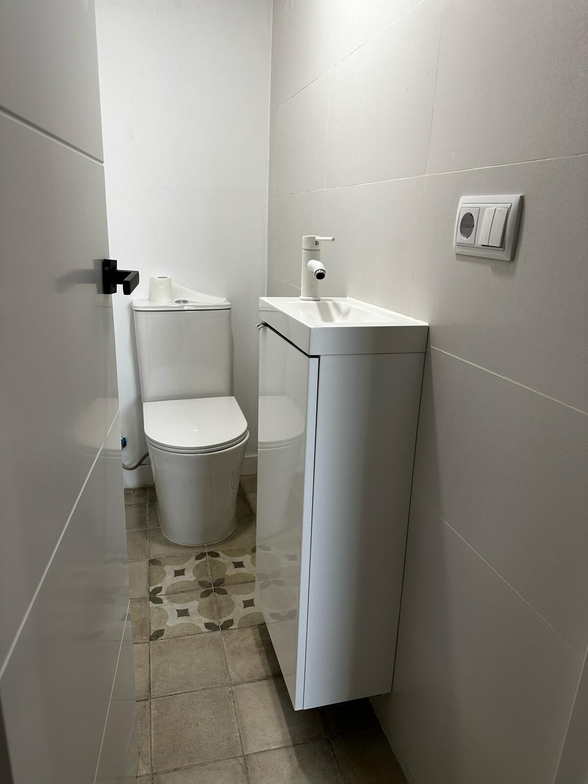 A small, modern bathroom with a toilet, bidet, and sink.