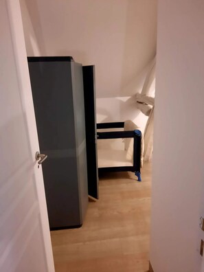 Una habitación con una cama, un escritorio y un armario.