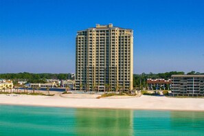 A tall, multi-story hotel with a modern design, located near a beach with clear turquoise waters. - Grand Escape! 3BR 3BA Sleeps 8 Gulf Views (Panama City Beach)