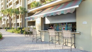 A bar area with a sign for 'AQUIRIS BEERS' and a 'Restrooms' sign. - Grand Escape! 3BR 3BA Sleeps 8 Gulf Views (Panama City Beach)
