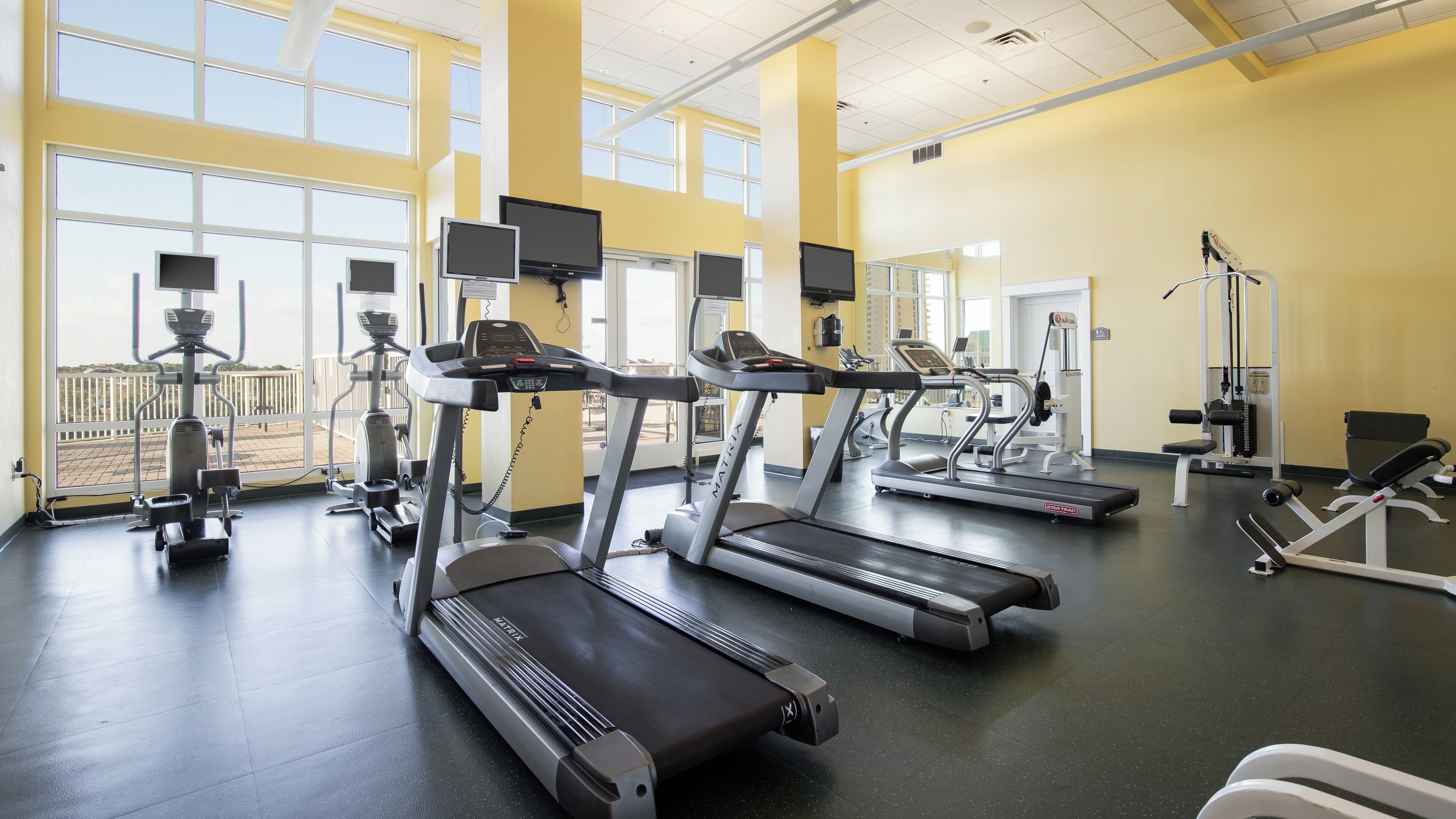 A gym with multiple treadmills, weight machines, and exercise equipment.