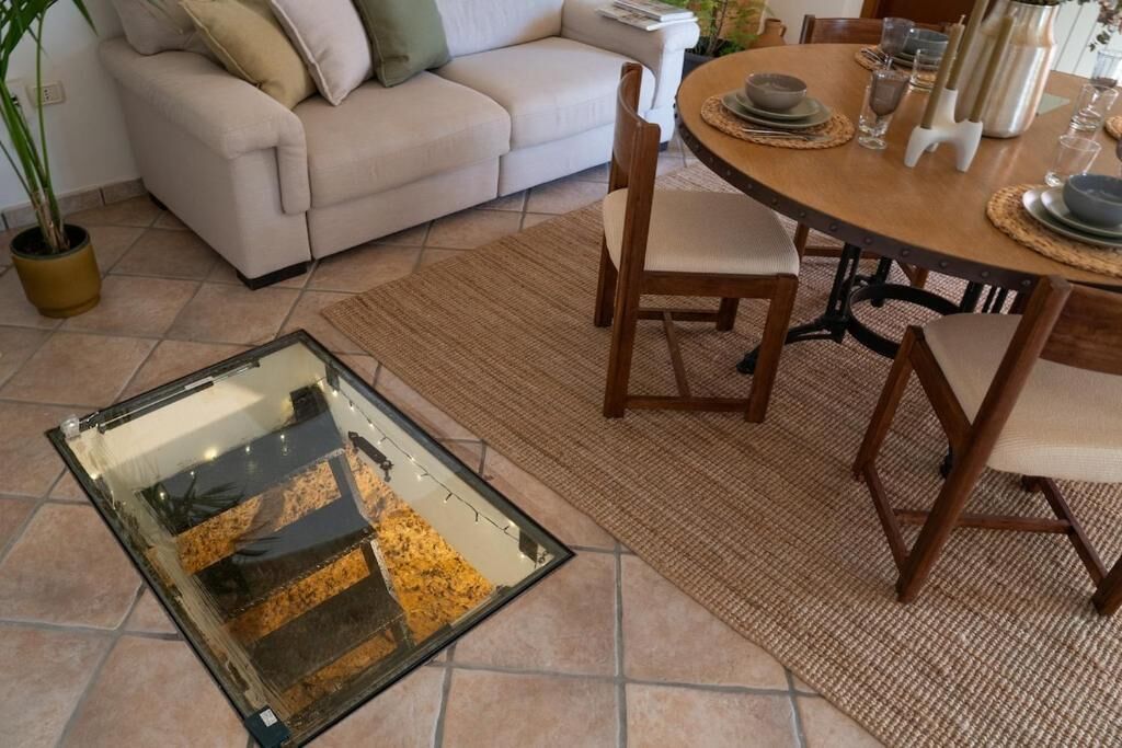 A dining area with a round table, chairs, and a glass-top table.
