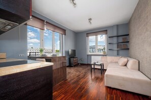 Una sala moderna con un sofá, una mesa de comedor y una zona de cocina con estufa.
