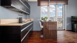 Una cocina moderna con estufa integrada, cafetera y ventana con vistas a un paisaje urbano.