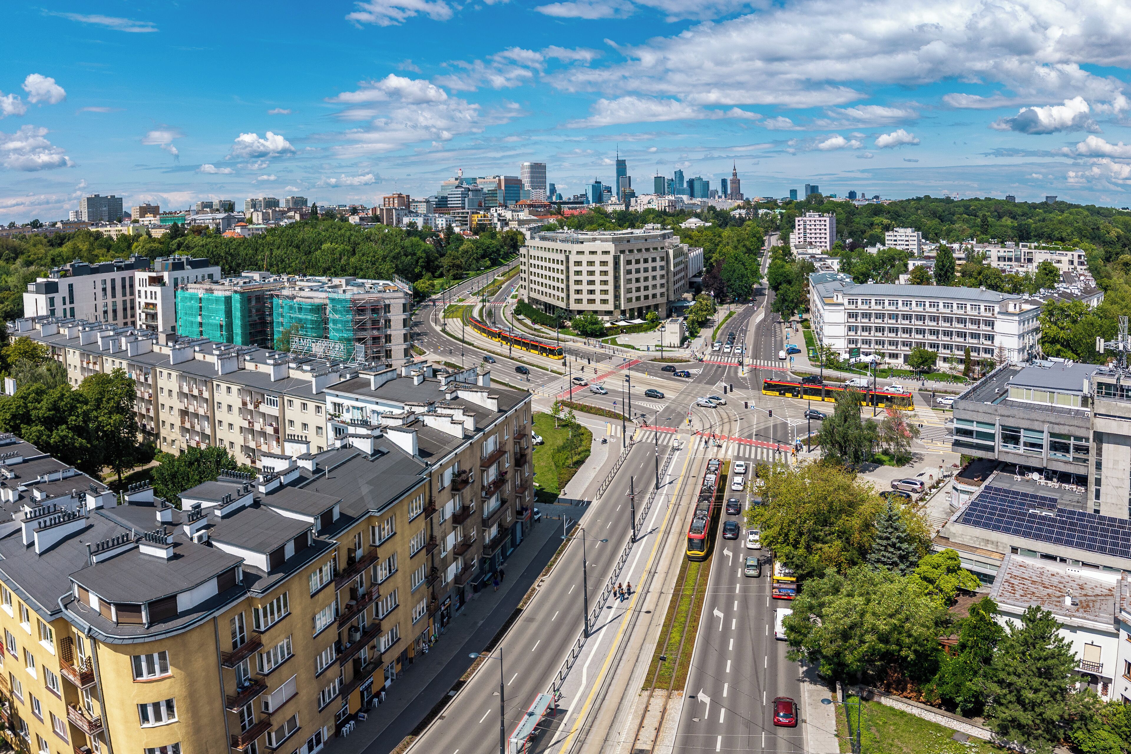 A cityscape with modern buildings, a busy intersection, and a clear sky.
