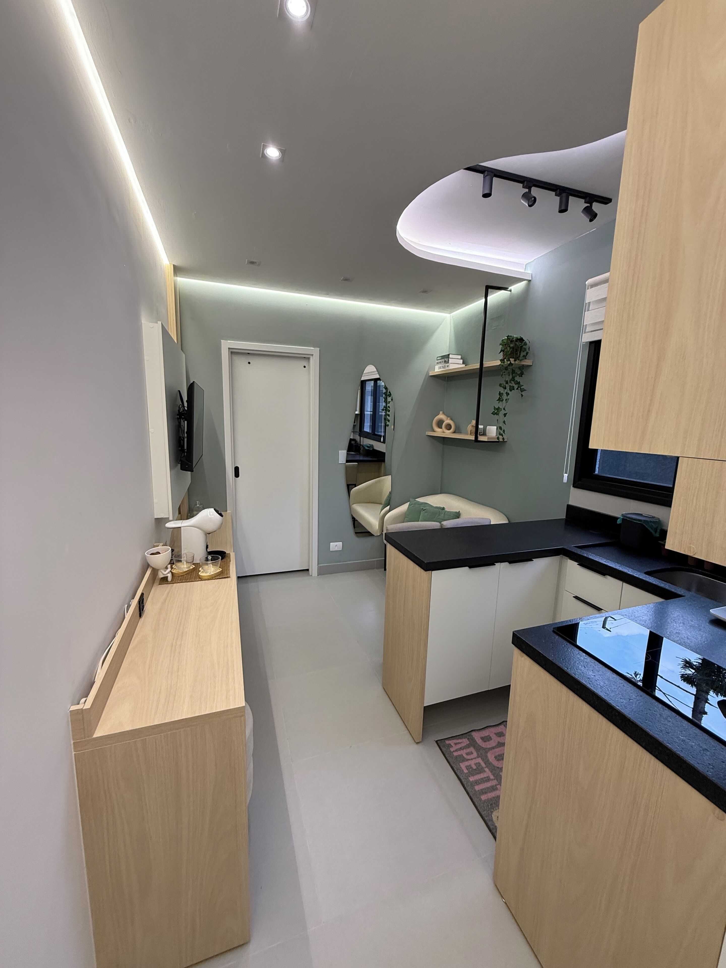 Uma cozinha moderna com uma ilha central, uma área de jantar com sofá e uma bancada com pia.