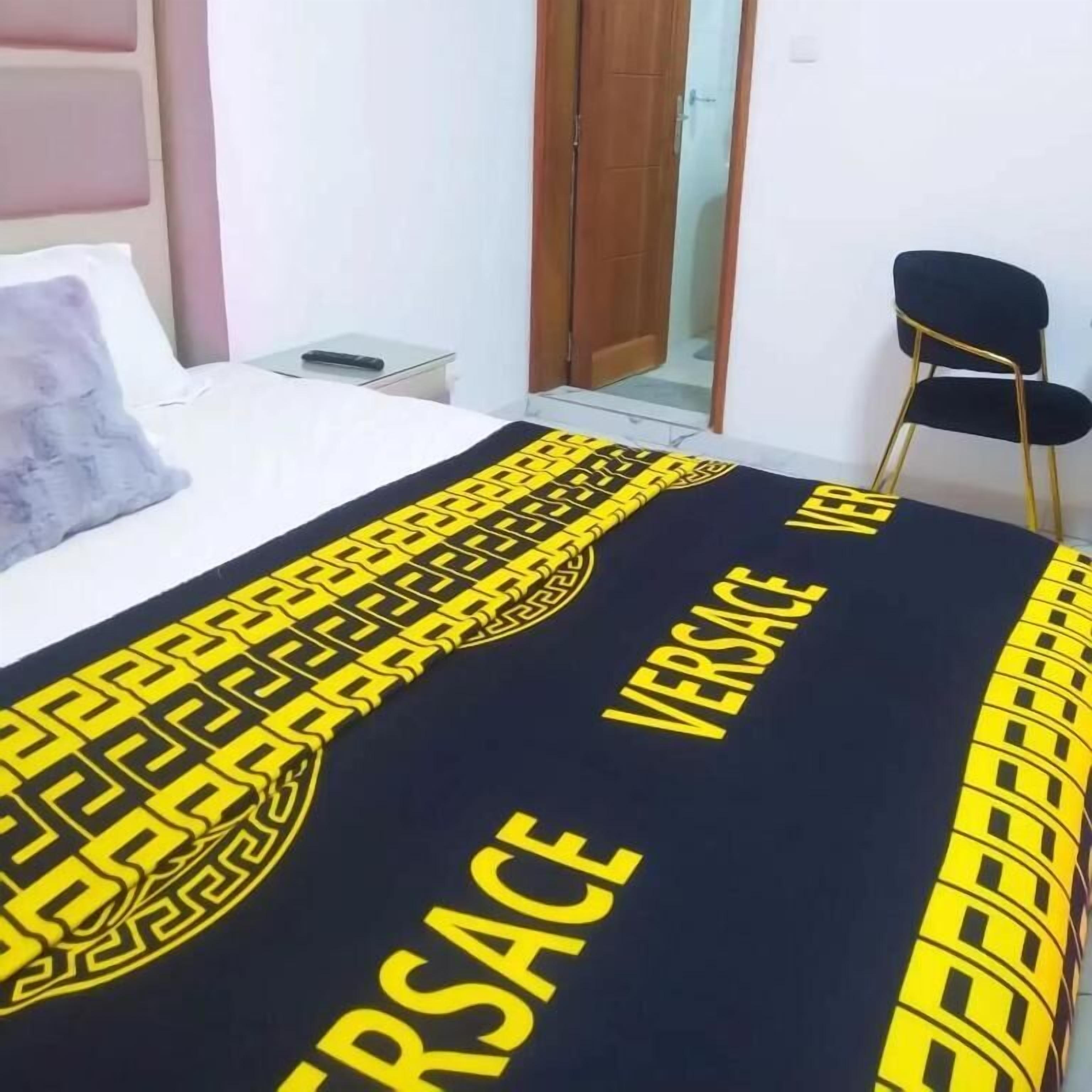 A hotel room with a bed, a chair, and a nightstand.