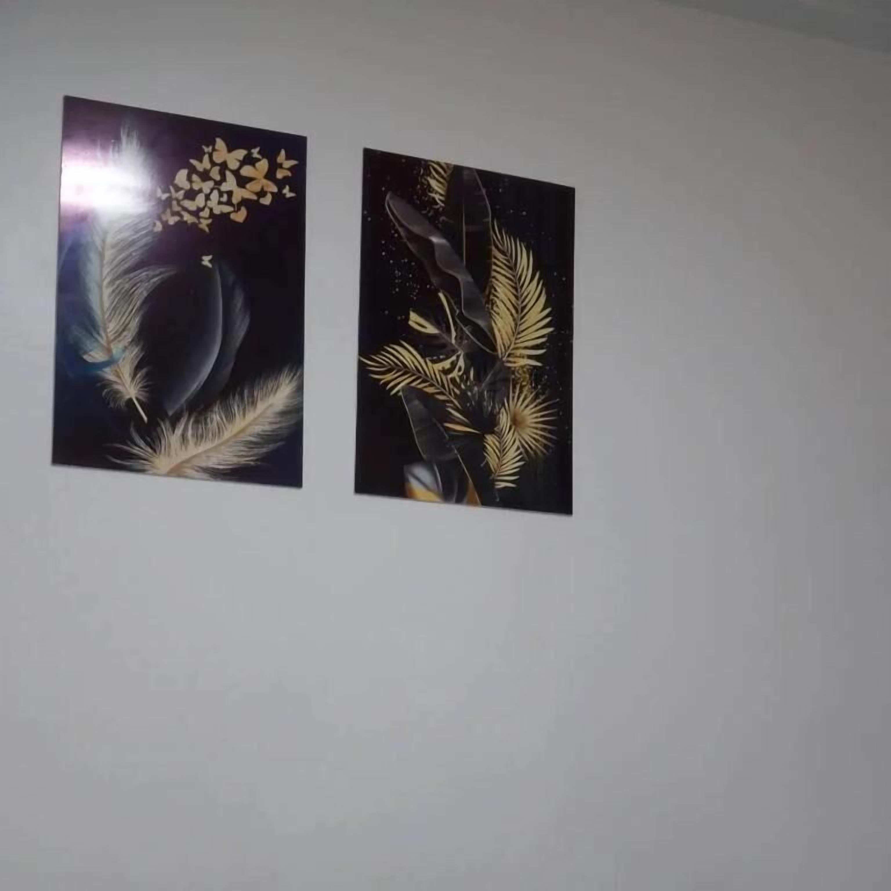Dos obras de arte colgadas en la pared, con motivos celestiales y botánicos.