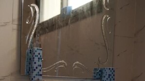 A bathroom with a mirror, a towel rack, and a shower area. - Chambre SCAT urbam (Dakar)