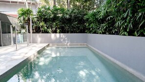 A swimming pool with a white wall and a metal fence. - Little Cove Luxury Escape (Noosa Heads)