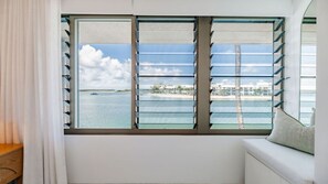 A room with a large window overlooking a body of water and a distant shoreline. - Bella Vista Waterfront Luxury (Noosaville)