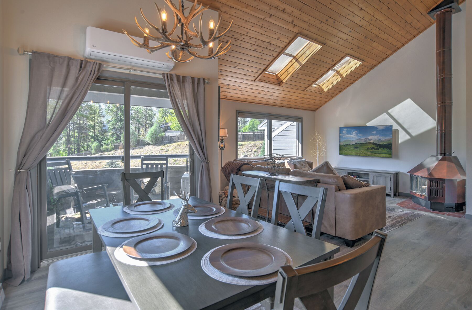 A dining area with a table set for four, a sofa, and a fireplace.