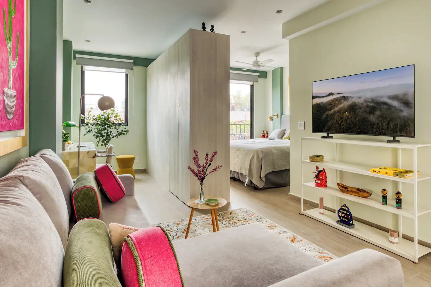 Un salon moderne avec un canapé, un téléviseur et une bibliothèque.