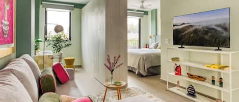 Un salon moderne avec un canapé, un téléviseur et une bibliothèque.