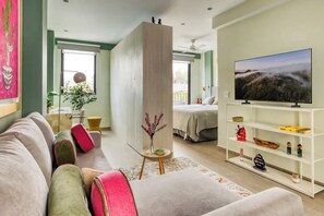 Ein modernes Wohnzimmer mit einer Couch, einem Fernseher und einem Bücherregal.
