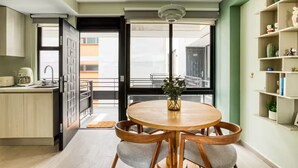 Eine moderne Küche mit Essbereich, Blick nach außen und einem Bücherregal mit Dekoration.
