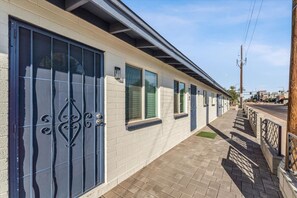 A row of single-story buildings with large windows and a paved walkway. - Downtown Chandler Escape – Walkable Location (Chandler)