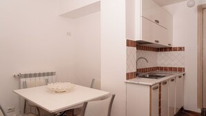 Cocina compacta con encimera blanca, un lavabo y un salpicadero con diseño de rombos.