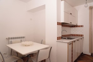 Cocina compacta con encimera blanca, un lavabo y un salpicadero con diseño de rombos.