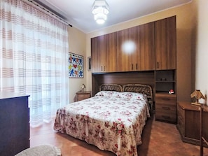 Ein Schlafzimmer mit einem Bett, einem Holzschrank und einem Nachttisch.