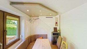 Ein Eckzimmer mit eingebauter Bank, einem Tisch und einem Stuhl.