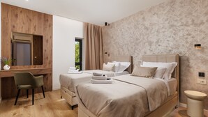 Et moderne hotelværelse med to senge, et skrivebord og en stol.