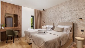 Ein modernes Hotelzimmer mit zwei Betten, einem Schreibtisch und einem Stuhl.