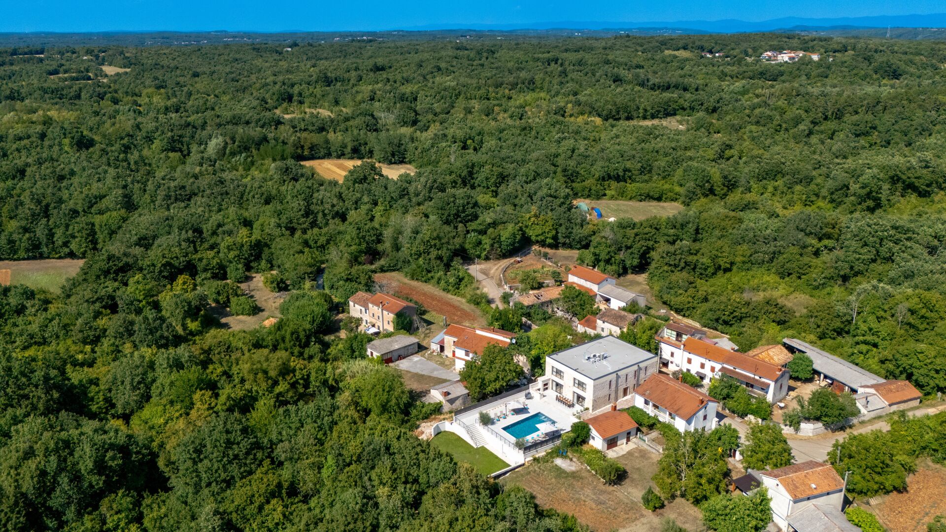 Un quartier résidentiel comprenant plusieurs maisons, une piscine et un grand espace vert.