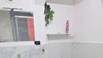 A modern bathroom with a white sink, vanity, and a toilet.