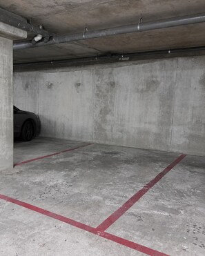 Eine Parkgarage mit Betonwänden und einem Auto im Hintergrund.