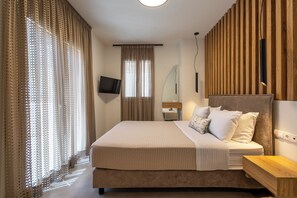 Ein Schlafzimmer mit einem Bett, einem Nachttisch, einem Fernseher und einer Wand aus Holzpaneelen.