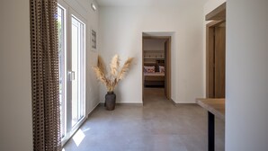 A hallway with a potted plant, a bed, and a wardrobe. - Eltynia Luxury Villa (KOUNAVOI)