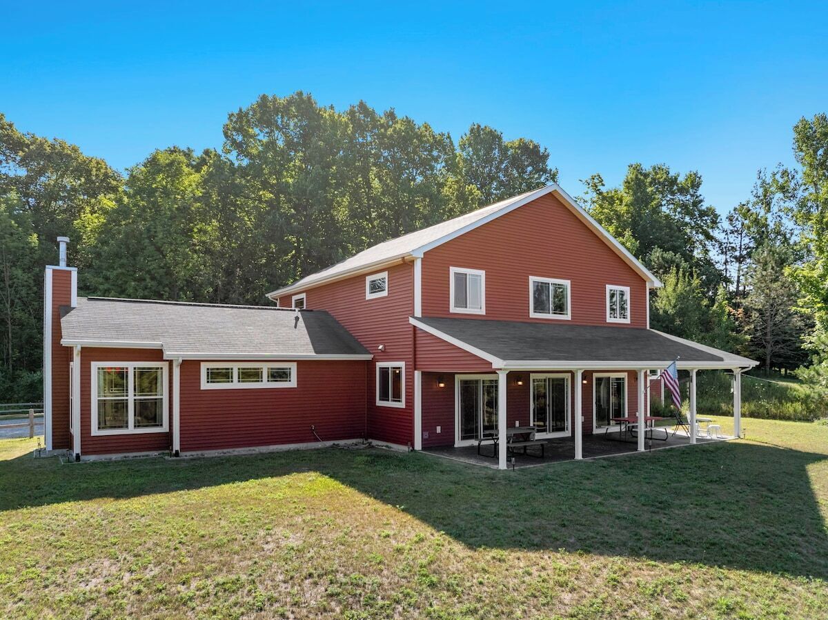 A two-story house with a covered patio and a separate garage.