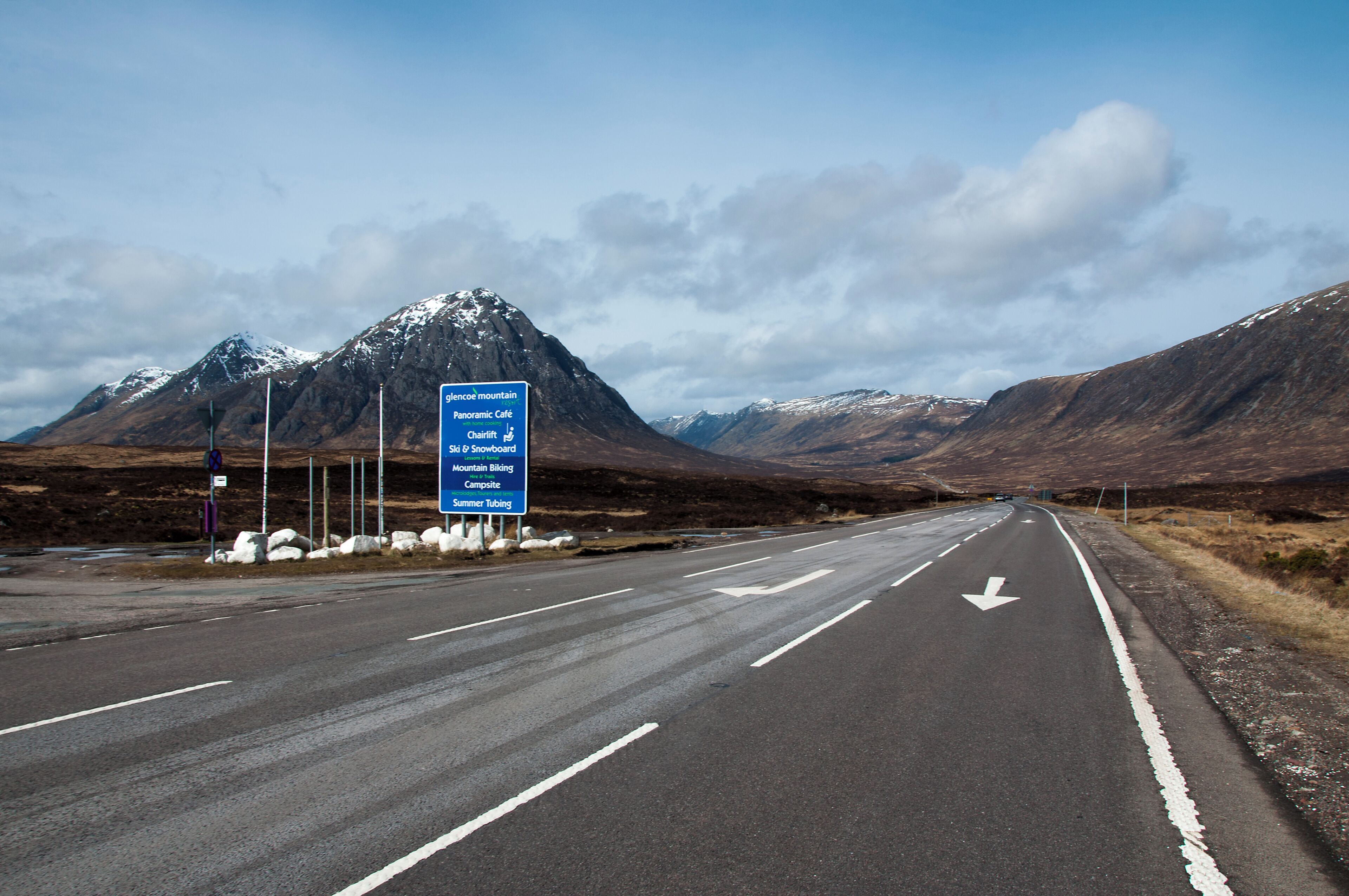 Une route avec un panneau indiquant la direction de Glencoe Mountain, du Panorama Café et d’autres commodités.