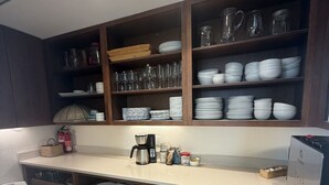A kitchen with wooden cabinets, a coffee maker, and various kitchenware.