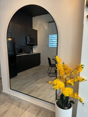 An interior view of a modern apartment with a kitchen, dining area, and a large window. - Trendy Beach Escape w/ 2 Kings (Carolina)
