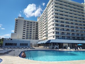 A hotel with a swimming pool, multiple floors, and a clear blue sky. - Luminoso estudio para 4 personas en la playa de Sunny Isles Beach STR-01464 (Sunny Isles Beach)