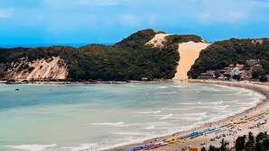 A coastal landscape with a beach, a mountain, and a clear sky. - Ahead Ponta Negra by Almare (Natal)